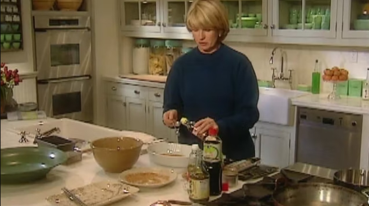 Martha Stewart cooking for her show Martha Stewart Living with her Jadite collection in the background.