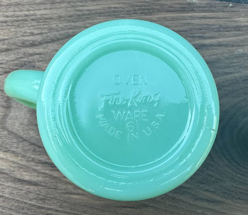 Close-up of a Fire-King Jadeite D-handle mug showing the raised ring base design.