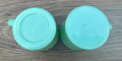 Two upside-down Fire-King Jadeite D-handle mugs shown side-by-side to highlight the difference between flat and ringed base styles.