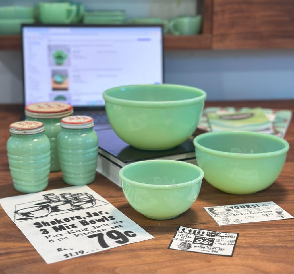 Fire-King Jadeite range set with beaded rim mixing bowls beside a laptop and vintage newspaper clippings.